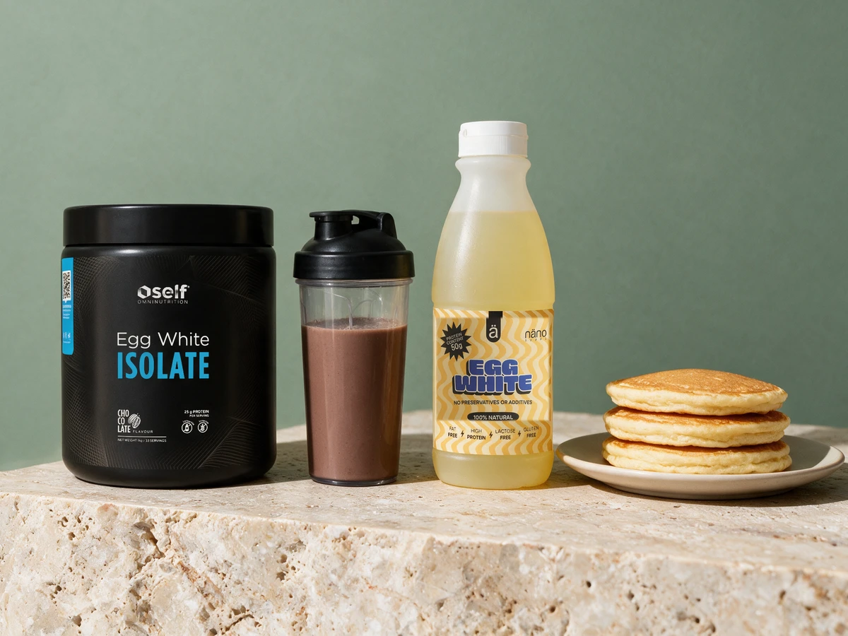 Self Egg White Isolate, en shaker med sjokoladedrikk, Nänosupps-flasken og pannekaker på en tallerken