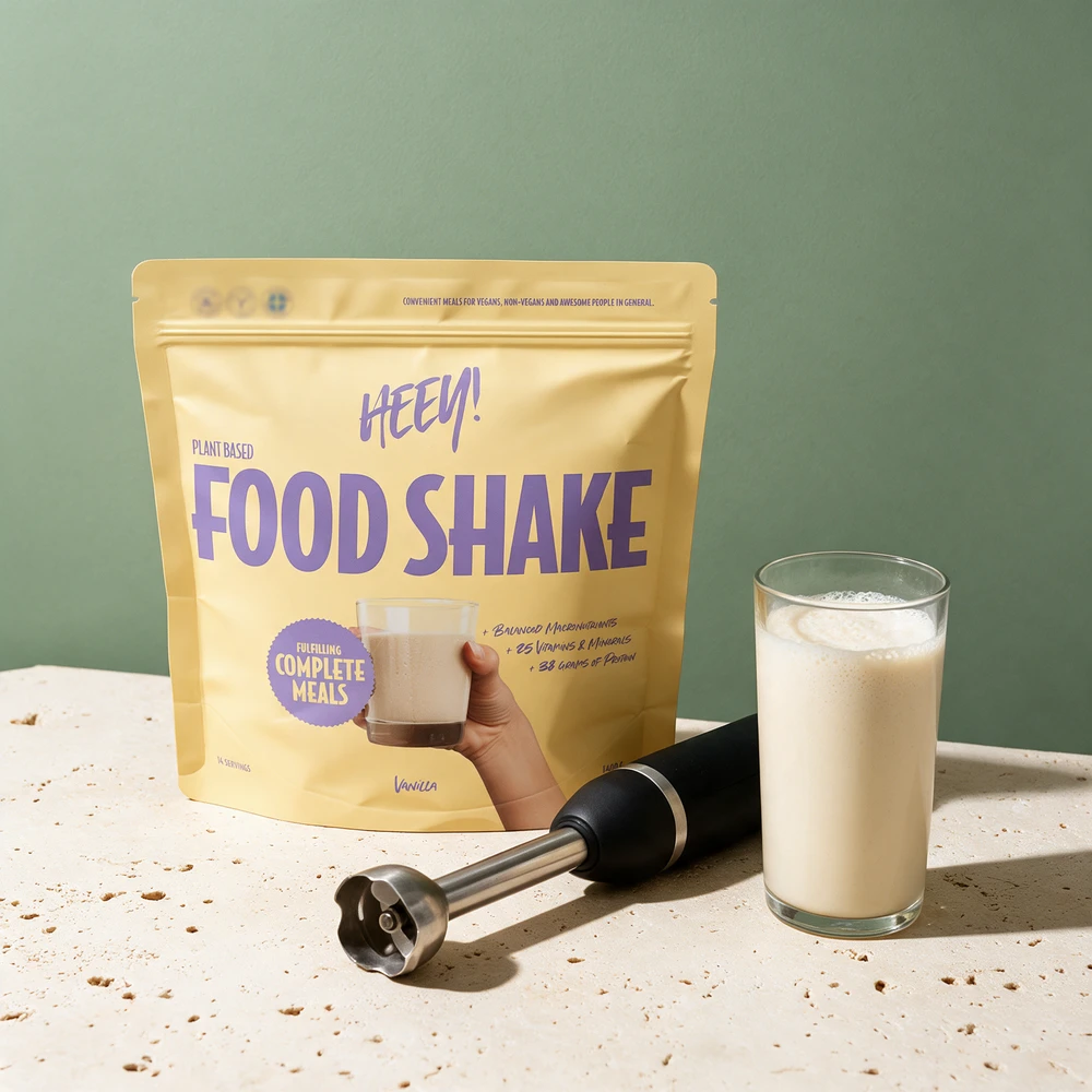 Heey! Plant Based Food Shake Vanilla, pose merket «25 Vitamins & Minerals» og «38 grams of protein», og en stavmikser