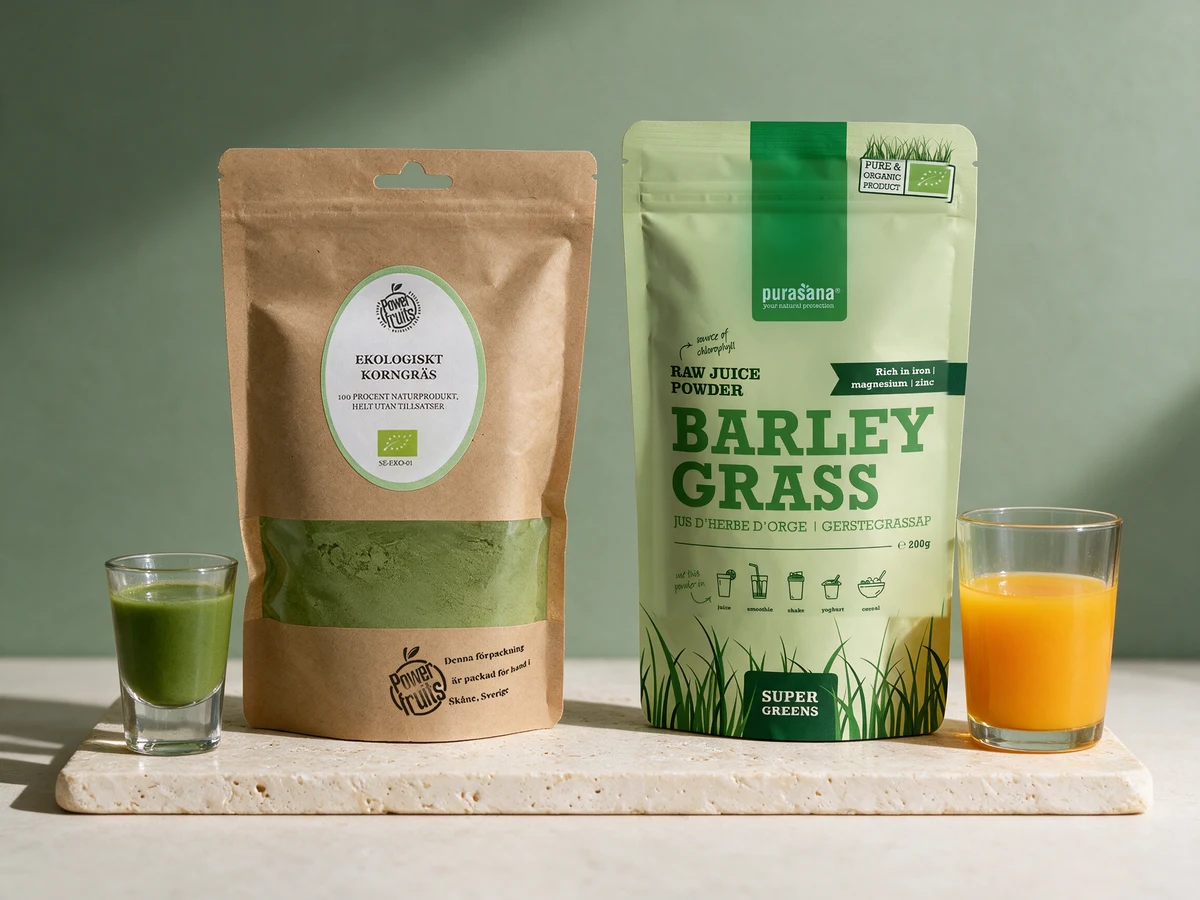 Powerfruits Byggress og Purasana Barley Grass, med et shotglass med grønn drikk og et glass appelsinjuice
