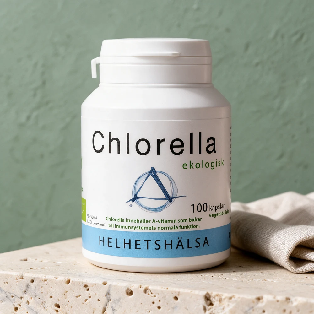 Helhetshälsa Chlorella i en hvit boks med blått bånd nederst på en travertinblokk ved en linserviett