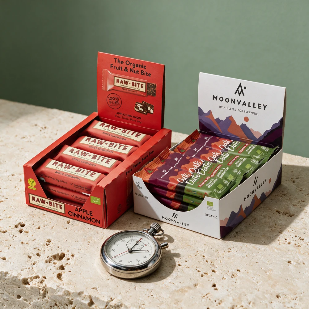 Rawbite Apple Cinnamon og Moonvalley Oats & Dates i åpne esker med tolv barer hver