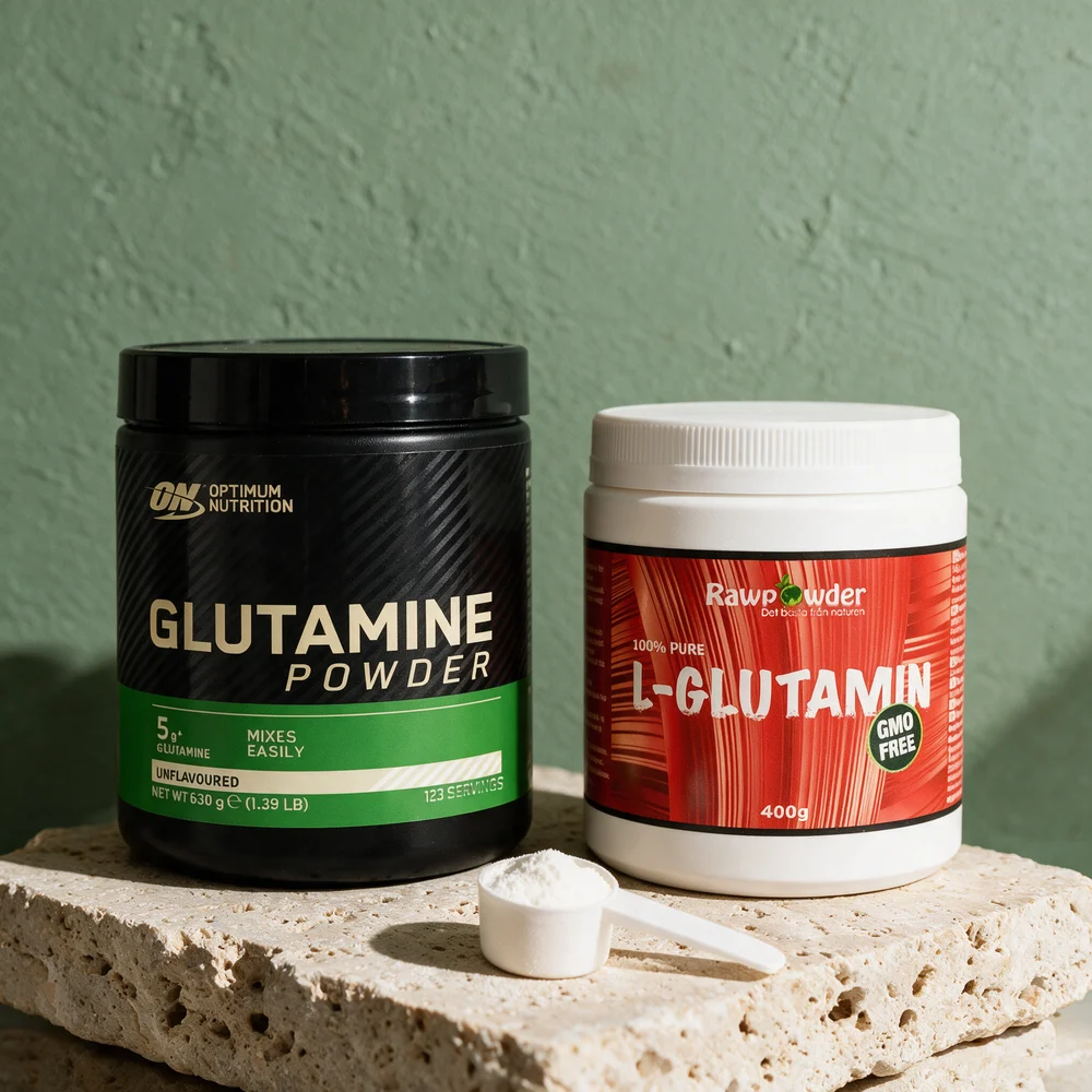Optimum Nutrition Glutamine Powder, svart boks, og Rawpowder L-Glutamin, hvit boks med rød etikett, med en hvit scoop pulver foran
