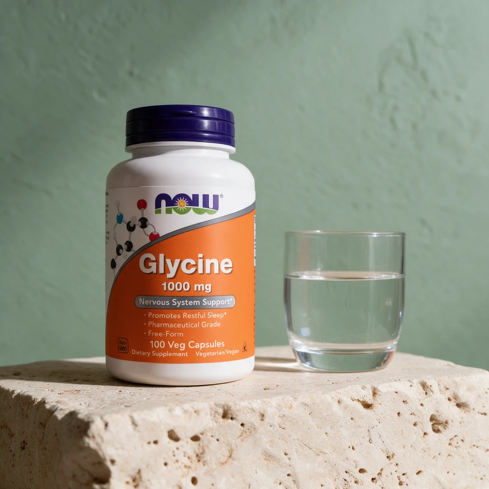 NOW Glycine 1000 mg, boks med 100 vegetabilske kapsler, med vannglasset ved siden