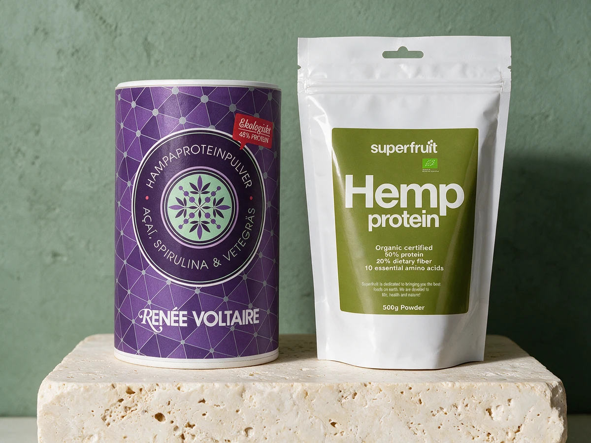 Renée Voltaire Smoothieboost, lilla papprør merket «Açaí, spirulina & vetegräs», og Superfruit Hemp protein, hvit pose merket «50% protein»