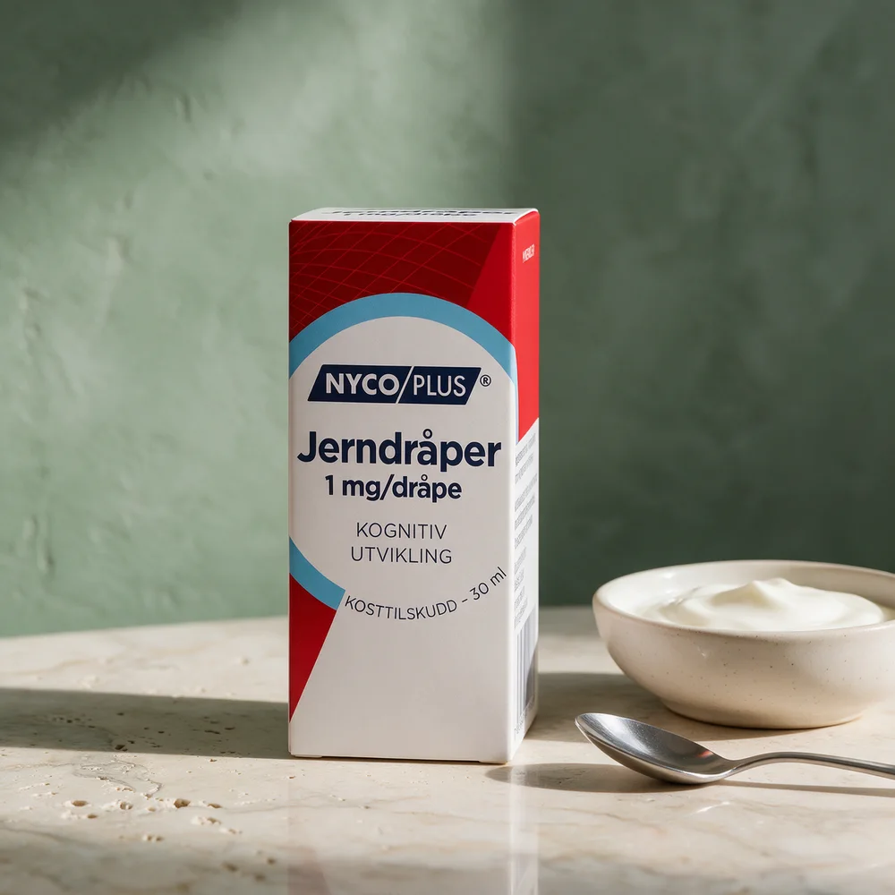 Nycoplus Jerndråper, eske med 30 ml merket 1 mg/dråpe, med en skje og en skål yoghurt