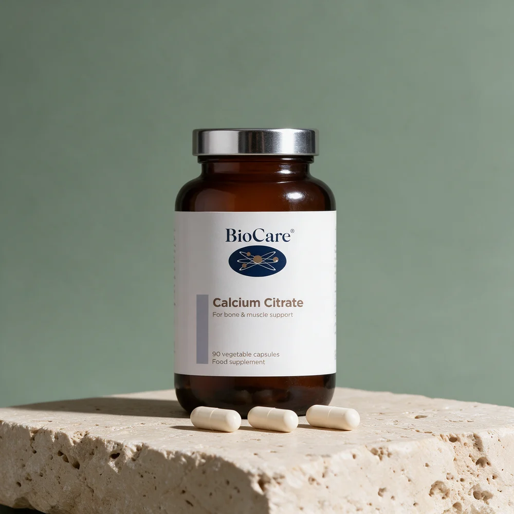 BioCare Calcium Citrate i mørk glasskrukke med tre kapsler foran, 100 mg kalsium i hver
