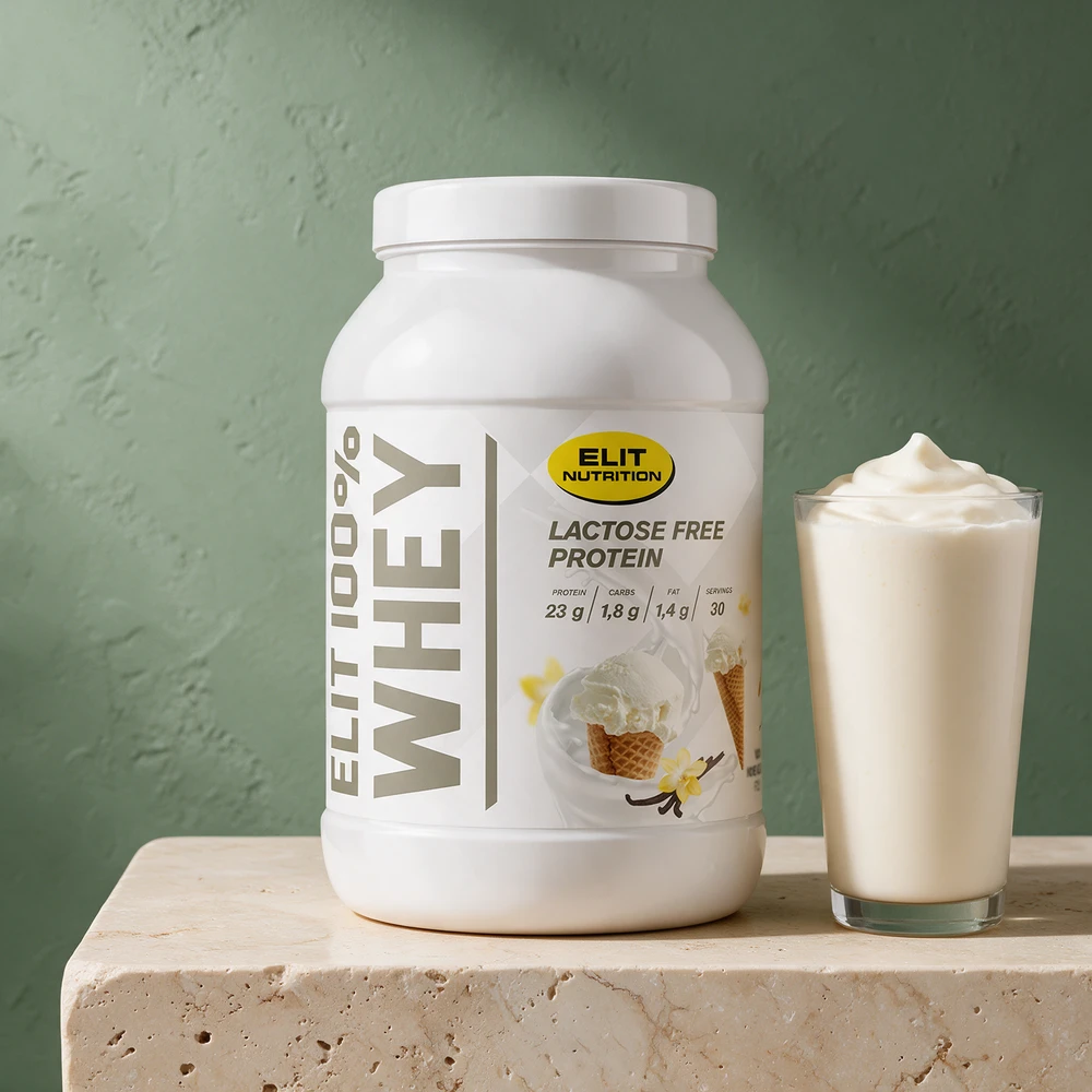 ELIT 100 % Whey med «Lactose Free Protein» på boksen ved et glass kremet vaniljeshake