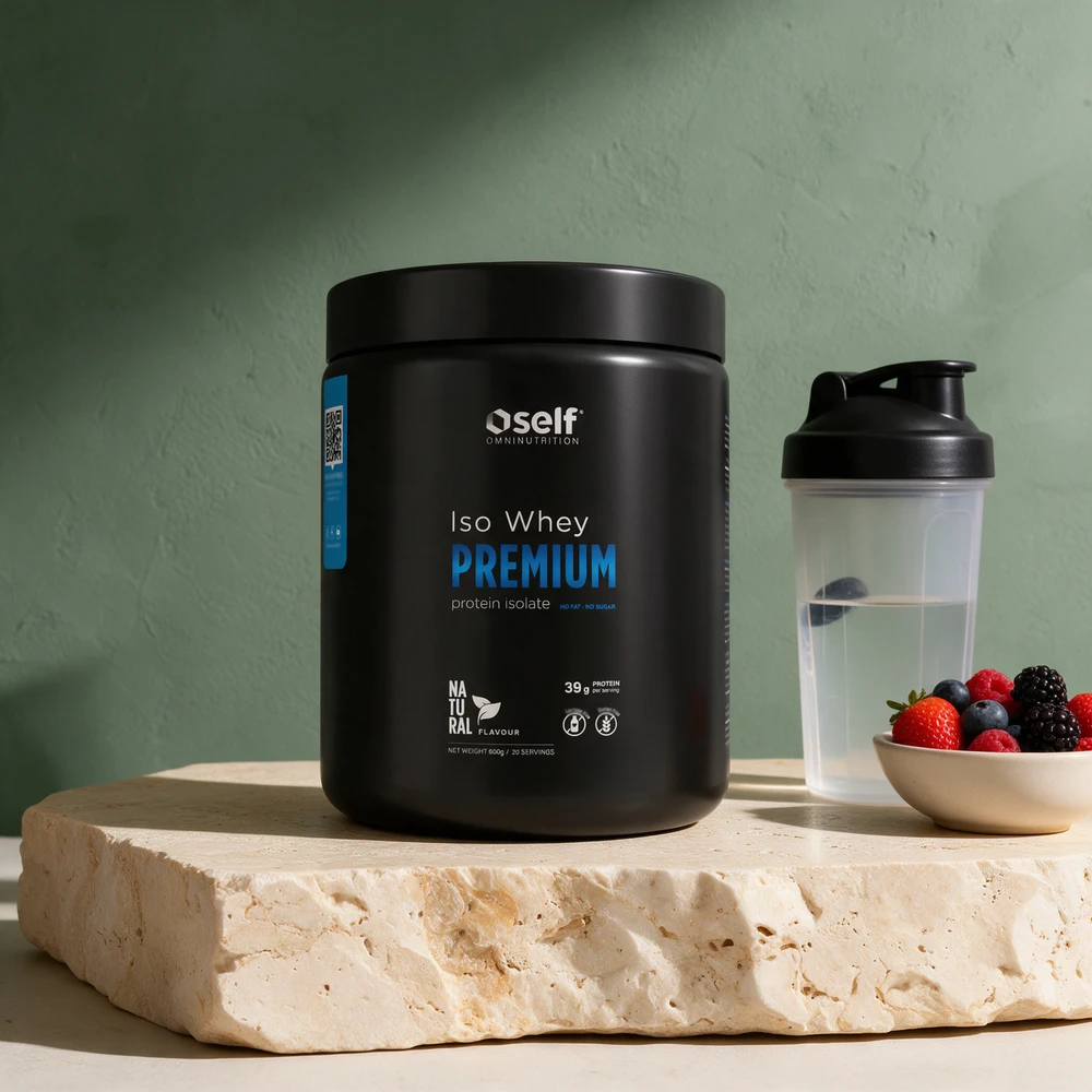 Self Omninutrition Iso Whey Premium Natural, svart boks, med en shaker vann og en skål bær