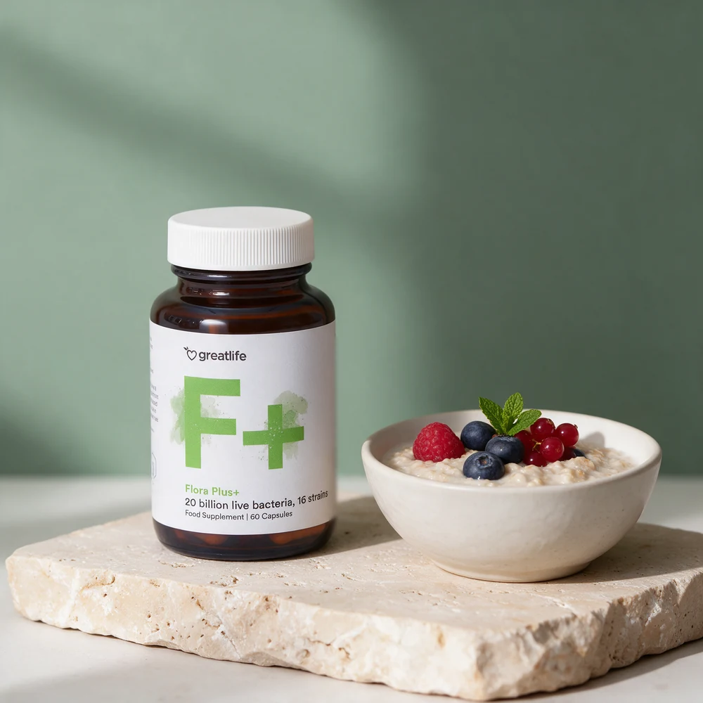 Greatlife Flora Plus+, glass med 60 kapsler merket 20 billion live bacteria og 16 strains, ved en skål kald havregrøt