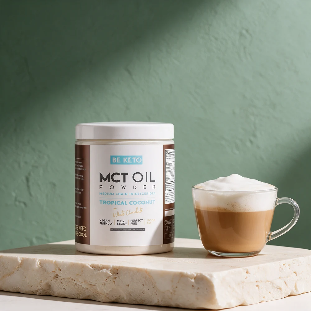 BeKeto Keto MCT Oil Powder i hvit boks merket «Tropical Coconut + White Chocolate» ved en kaffe latte