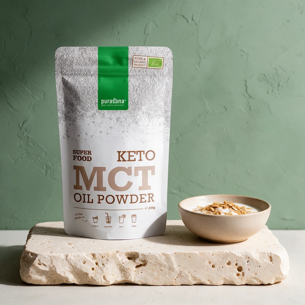 Purasana Keto MCT Oil Powder i sølvhvit pose ved en skål yoghurt med müsli