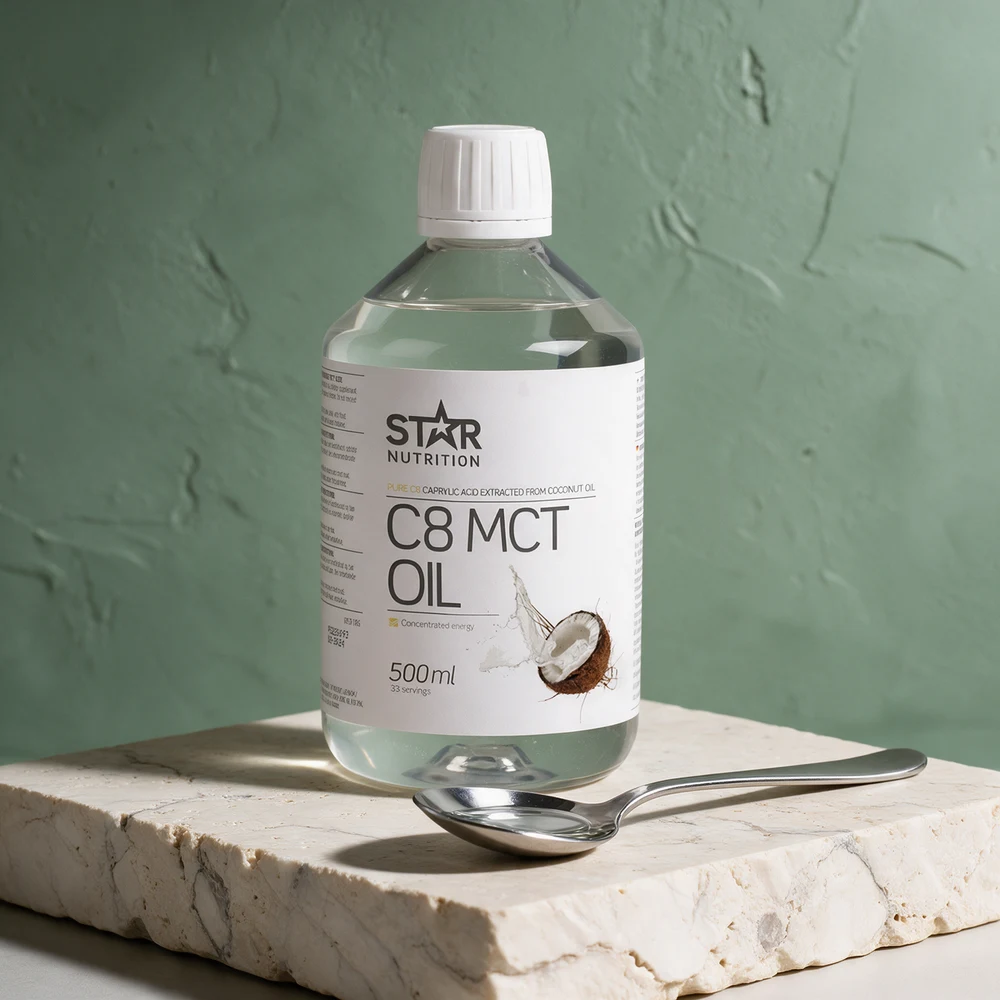 Star Nutrition C8 MCT Olje i klar flaske med en spiseskje vannklar olje foran