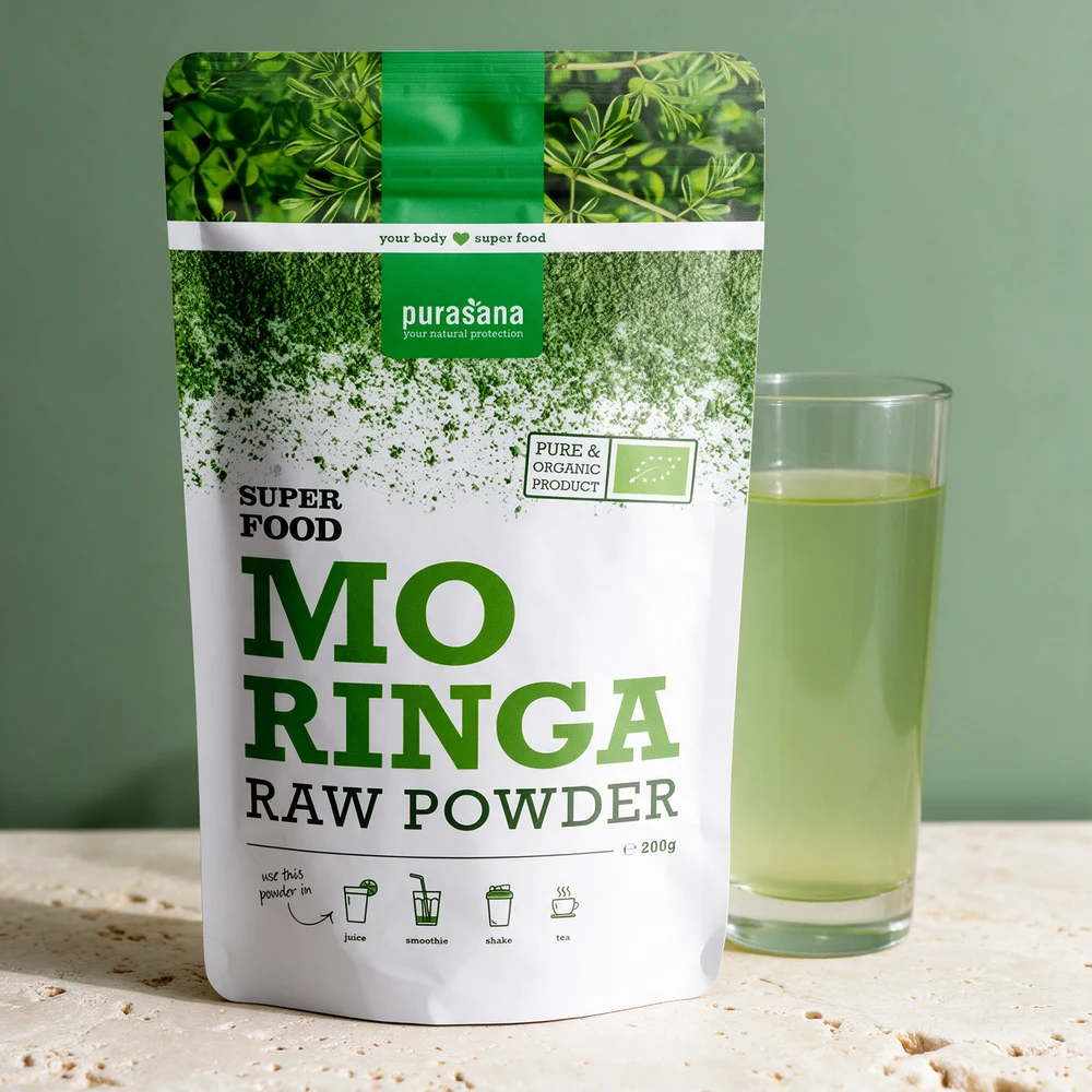 Purasana Moringa Raw Powder, hvit og grønn pose med 200 gram, ved et høyt glass lysegrønn drikk
