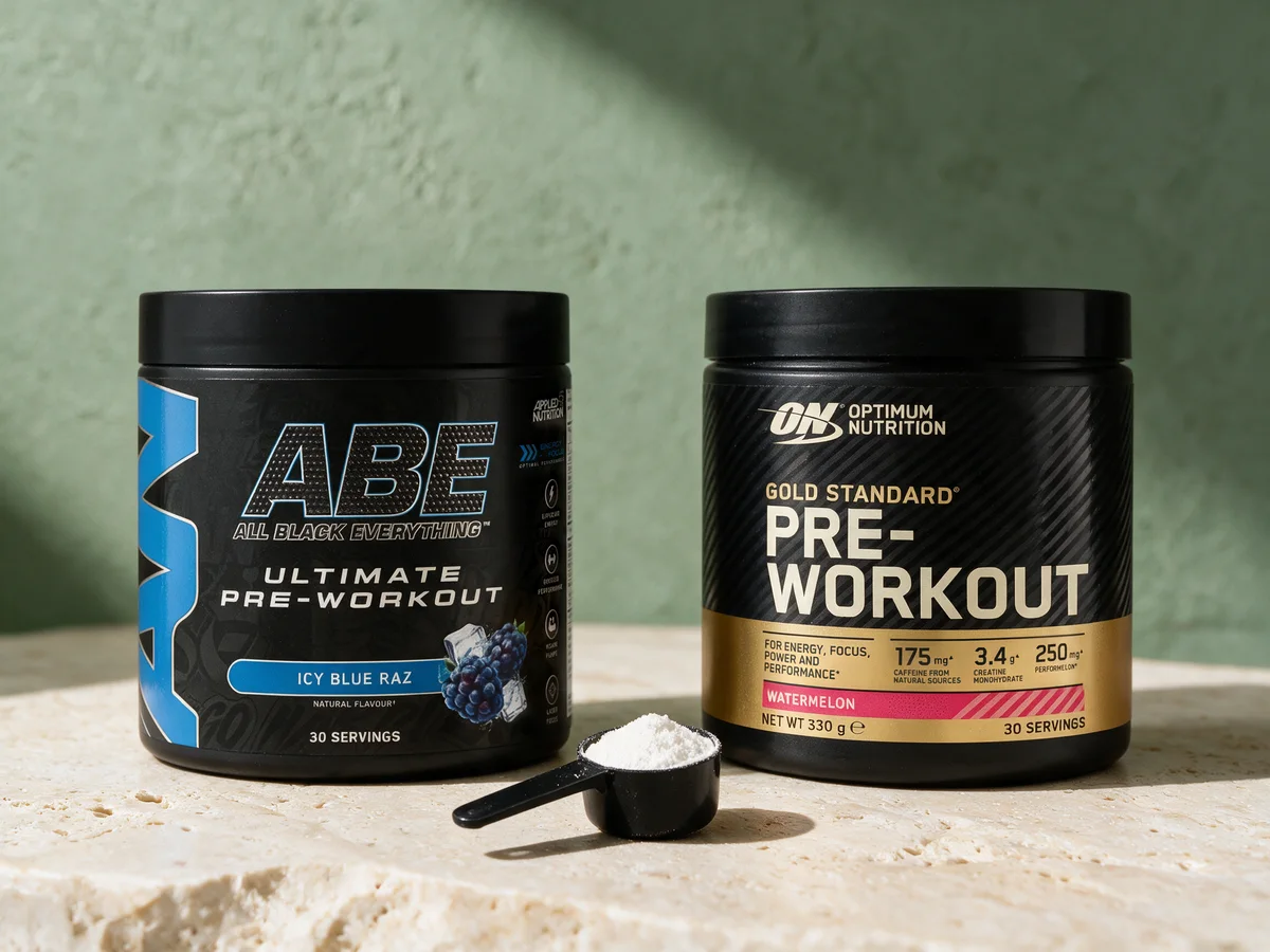 Applied Nutrition ABE Icy Blue Raz og Optimum Nutrition Gold Standard Pre-Workout Watermelon med en måleskje hvitt pulver