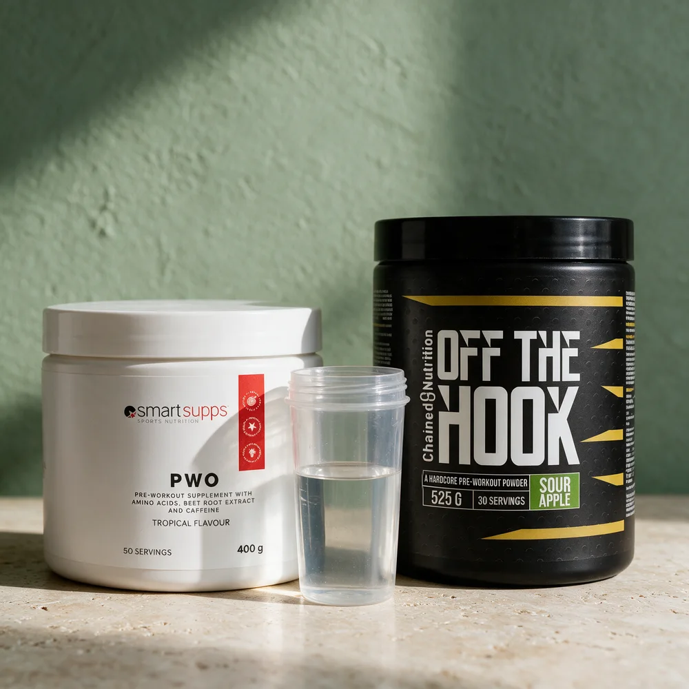 SmartSupps PWO Tropical og Chained Nutrition Off The Hook Sour Apple ved siden av hverandre med en shaker