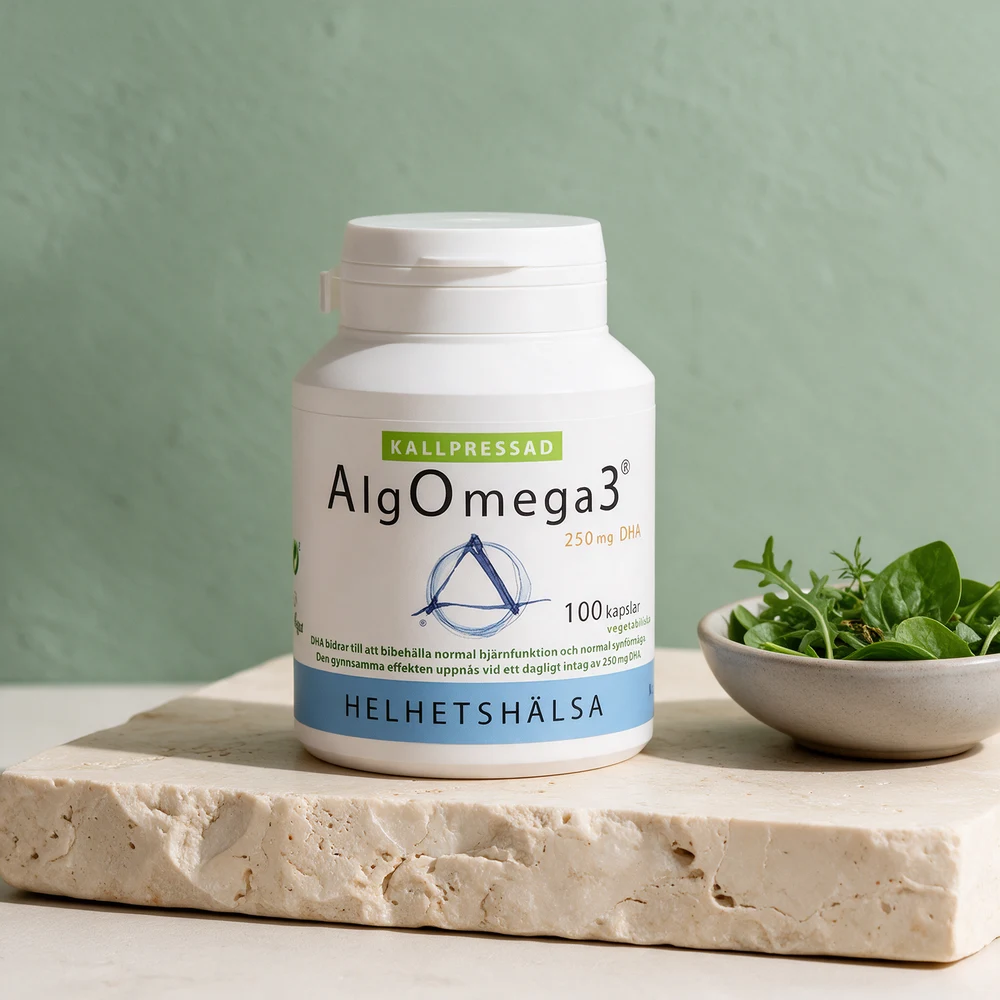 Helhetshälsa AlgOmega3 kaldpresset i hvit boks med vippelokk og blått bånd ved en skål salat på et travertinbord