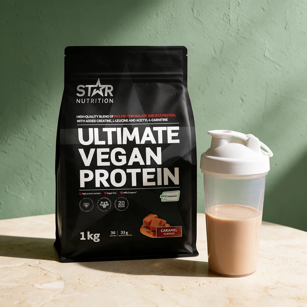 Star Nutrition Ultimate Vegan Protein i svart pose, med en fylt shaker ved siden av på travertin