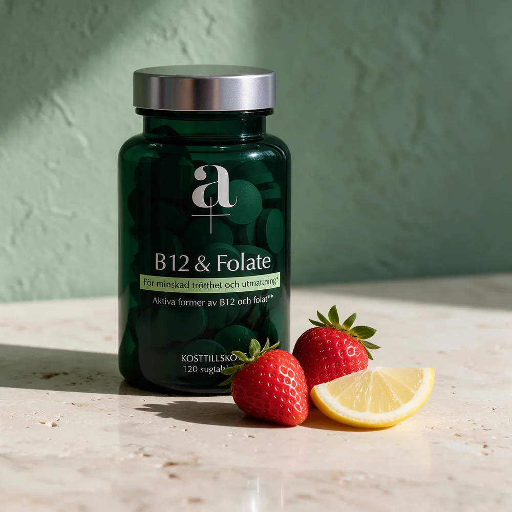 Alpha Plus Metyl B12 & Folat i mørkegrønt glass ved to jordbær og en sitronbåt på et travertinbord