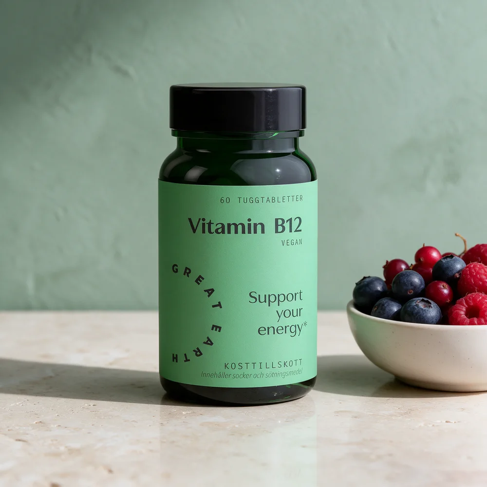 Great Earth Vitamin B12 i mørkegrønt glass med mintgrønn etikett og en skål skogsbær på et travertinbord