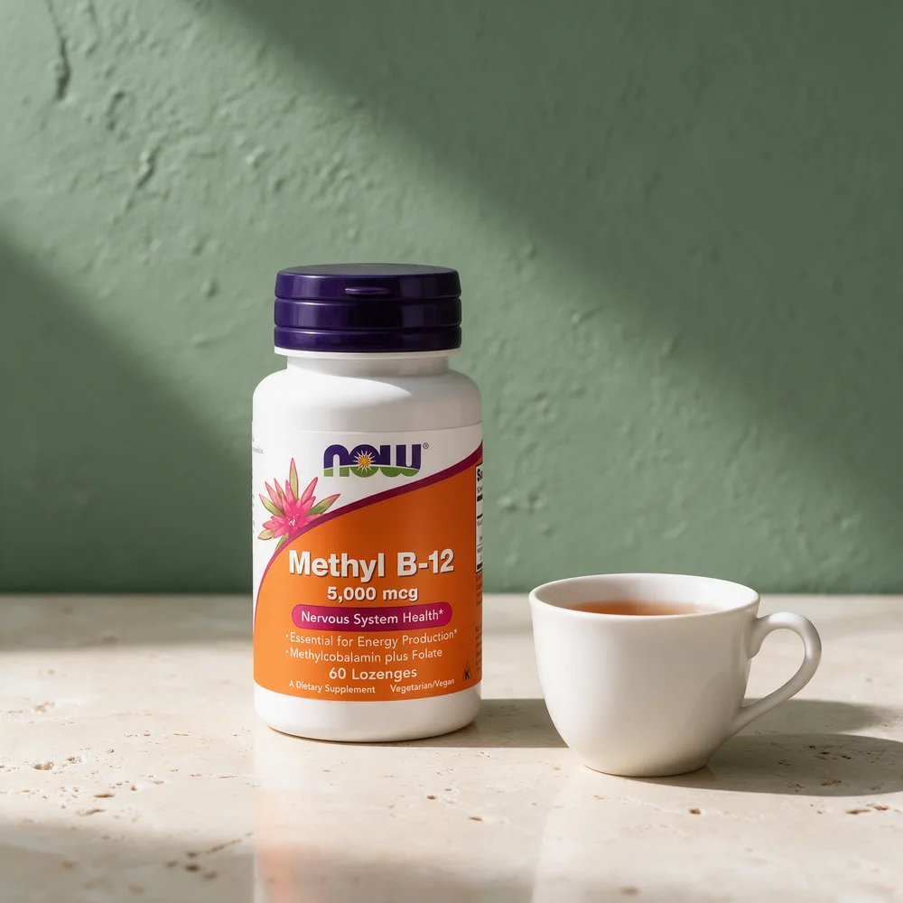 NOW Methyl B-12 5000 mcg i hvit flaske med lilla lokk, og en tekopp på travertin