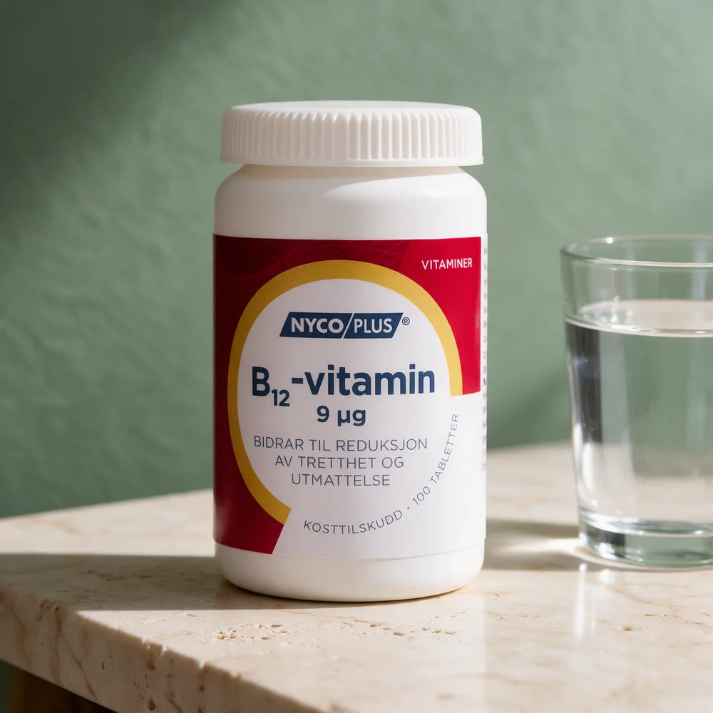 Nycoplus B12-vitamin 9 µg i boks med små tabletter og et glass vann på et travertinbord