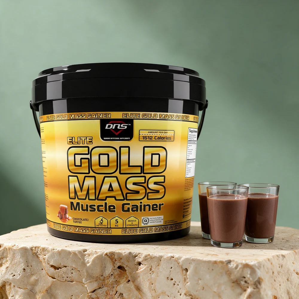 Gul bøtte med DNS Elite Gold Mass Chocolate Toffee og tre små glass sjokoladeshake på et travertinbord